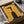 May include: Vintage-style French poster with yellow background featuring stylized black-haired woman's profile and the words "prestige" and "chic" in red text. Framed artwork shown in open cardboard shipping box with protective tissue paper wrapping and wooden dowels for secure packaging.