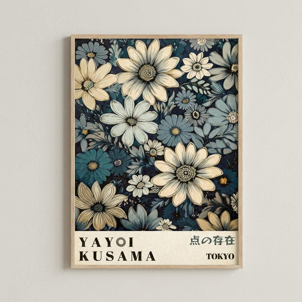 May include: Framed poster print displaying a dense floral pattern with cream, white, and blue daisy-like flowers against a dark navy background, mounted on a light gray wall. The artwork features botanical illustrations in muted tones with visible texture and detail in the petals and centers. Below the floral design, white text reads "YAYOI KUSAMA" and Japanese characters, along with "TOKYO" in a clean, minimal layout within a light wood frame.