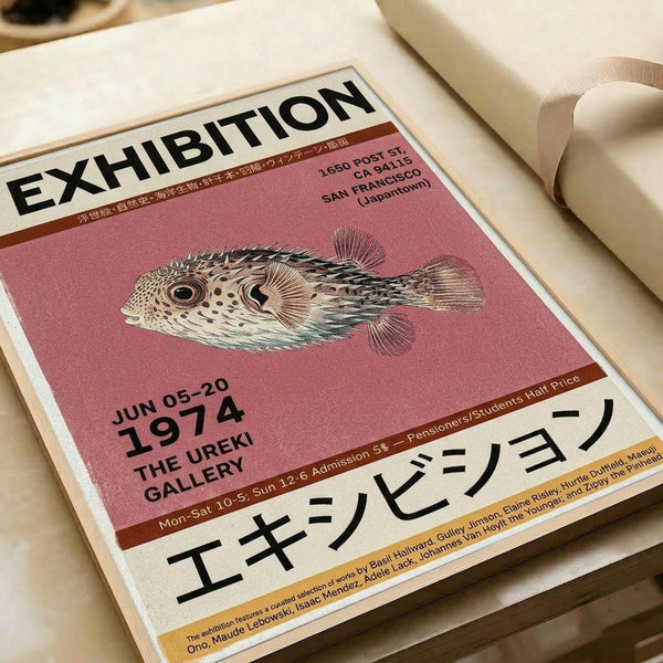 May include: Vintage-style exhibition poster with pink background featuring detailed illustration of spotted pufferfish. Black text reads "EXHIBITION" at top and "JUN 05-20 1974 THE UREKI GALLERY" below fish. Japanese characters visible at bottom. Poster appears mounted or framed, photographed at angle on neutral surface with soft lighting and white objects partially visible in background.