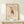 May include: Framed poster print featuring geometric owl artwork in Picasso's minimalist style, displayed on light wood shelf against cream wall. Owl composed of colorful angular shapes - red triangular head accent, yellow and blue geometric body sections, orange-brown wing, thin black line legs. Natural wood frame with cream matting. Small white geometric object sits beside frame on shelf. Soft natural lighting creates gentle shadows.