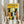 May include: Person holding framed cat poster with dried pampas grass. Yellow background features illustrated cats in various colors - black, orange, striped, and white - arranged in group formation. Bold "FELINES" text at top. Light wood frame against white curtained window background.