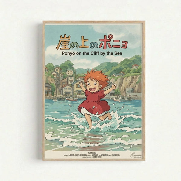 Framed poster showing Ponyo, a red-haired character in a burgundy dress, splashing joyfully in ocean waves. Behind her is a picturesque coastal town with traditional buildings nestled among green hills and cliffs. Boats dot the harbor waters. The artwork features Studio Ghibli's signature animation style with soft, muted colors. Japanese text appears at the top with English subtitle "Ponyo on the Cliff by the Sea" below. Light wood frame against white wall.