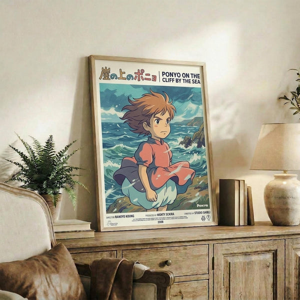 May include: Framed Studio Ghibli Ponyo poster featuring young girl with flowing brown hair in coral dress sitting by turbulent ocean waves, displayed on rustic wooden sideboard alongside fern plant, ceramic vase, and stacked books in cozy living room with beige armchair and neutral walls