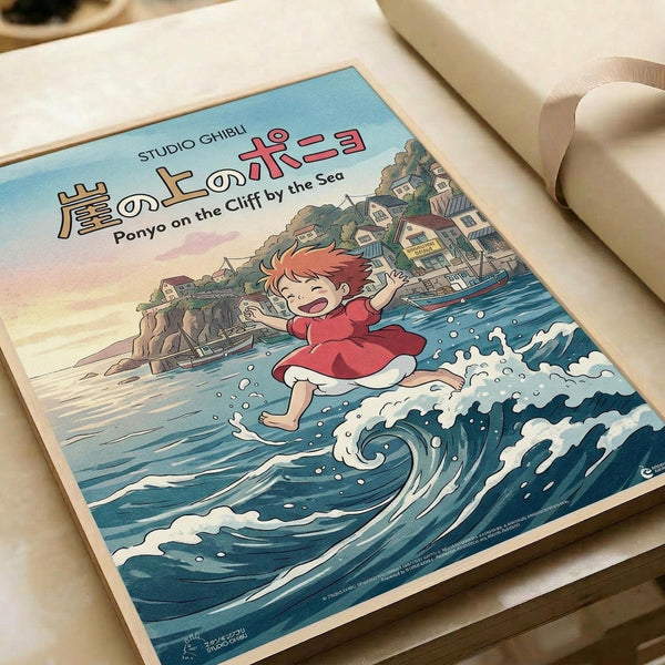 Studio Ghibli poster print featuring Ponyo, a red-haired child character in a bright red dress, joyfully running across stylized blue ocean waves. The background shows a picturesque coastal town with traditional buildings nestled on hillside cliffs. Japanese text appears at the top with English subtitle "Ponyo on the Cliff by the Sea." The artwork displays classic anime illustration style with vibrant blues, soft pastels, and detailed linework. The poster is placed on white paper with white ribb