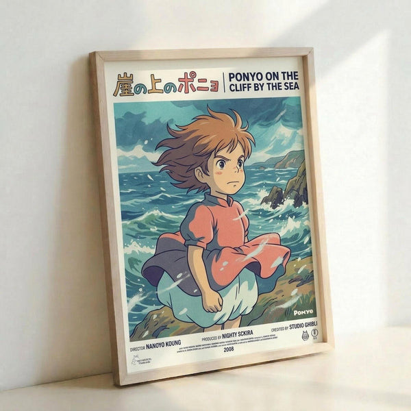 May include: Framed anime-style poster showing a young girl with flowing brown hair in a pink and blue striped dress, sitting by turbulent ocean waves. The artwork features Japanese text and "PONYO ON THE CLIFF BY THE SEA" title, with Studio Ghibli branding. Light wooden frame displayed against white wall, showing detailed watercolor-style illustration with dynamic seascape background in blues and greens.