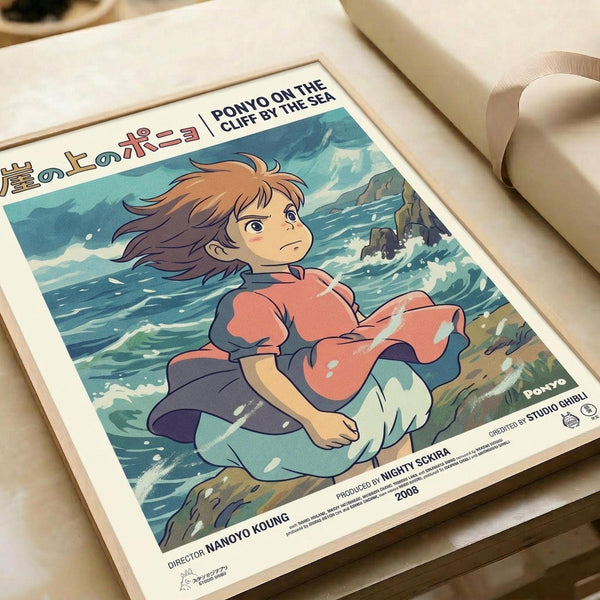 Studio Ghibli-style anime poster featuring a young girl with flowing reddish-brown hair wearing a coral pink sweater, sitting by turbulent ocean waves crashing against rocky cliffs. The artwork displays Japanese text at the top and English text reading "PONYO ON THE CLIFF BY THE SEA" along with production credits at the bottom. The poster has a vintage film poster aesthetic with soft, painterly colors in blues, greens, and coral tones. The print is displayed on cream-colored paper with white mat