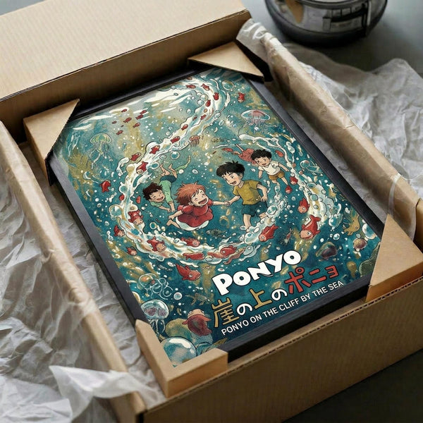 May include: Framed poster print featuring underwater scene with cartoon children swimming among red fish, jellyfish, and sea creatures in swirling blue-green waters with white bubbles and foam. Print shows Japanese anime art style with warm colors and whimsical characters. Black frame sits in cardboard shipping box with protective packaging materials on wooden surface.