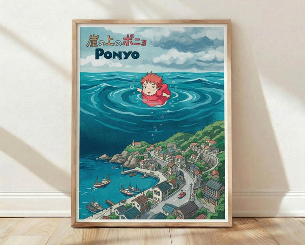May include: A framed poster print displayed on wooden flooring against a white wall with natural shadows. The artwork features Studio Ghibli's distinctive animation style showing the character Ponyo floating in ocean water above a detailed coastal Japanese village with traditional houses, boats in the harbor, and lush green hills. The image has vibrant blues for the ocean, cloudy sky background, and includes Japanese text at the top. The poster is mounted in a natural wood frame.