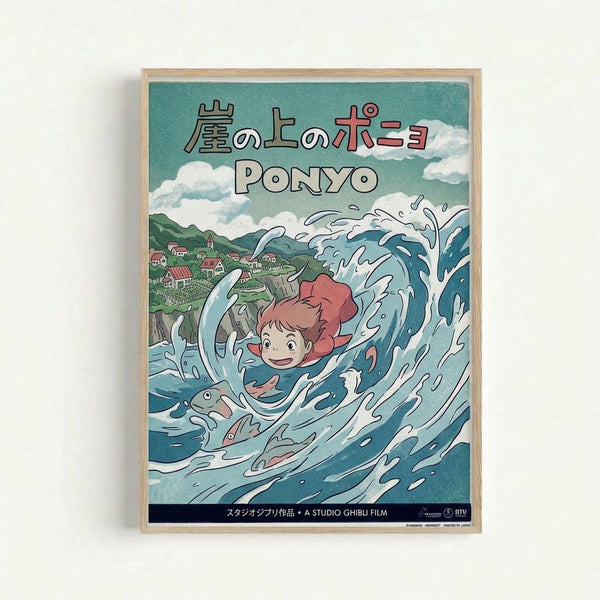 Framed Studio Ghibli Ponyo poster featuring the red-haired character surfing through a large blue wave with a fish companion. The artwork shows a green coastal village with houses in the background under a cloudy sky. Japanese text appears at the top with "PONYO" in large letters below. The illustration uses a colorful anime art style with dynamic water splashes and movement. Black text band at bottom indicates Studio Ghibli film credit. Natural wood frame against white wall.