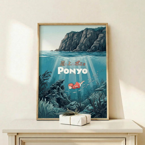 May include: Framed poster displayed on light wood shelf against white wall. Artwork shows underwater scene with rocky cliffs above water surface, Japanese text and "PONYO" title in white letters. Small character with red hair swims among dark seaweed and coral in blue-green waters with sun rays streaming down. Natural wood frame, small wrapped gift box on shelf beside poster.