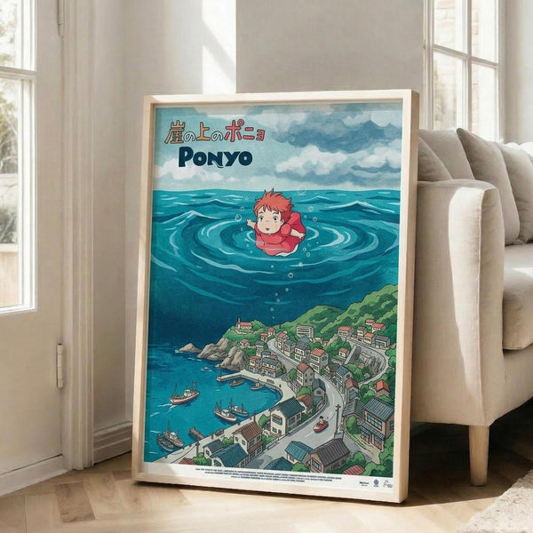 May include: Framed poster displayed in bright living room next to beige armchair and windows. Artwork shows anime character Ponyo floating in ocean waves above coastal Japanese village with boats and traditional buildings. Features blue water, cloudy sky, and Japanese text at top. Light wood frame against white walls on hardwood floor.