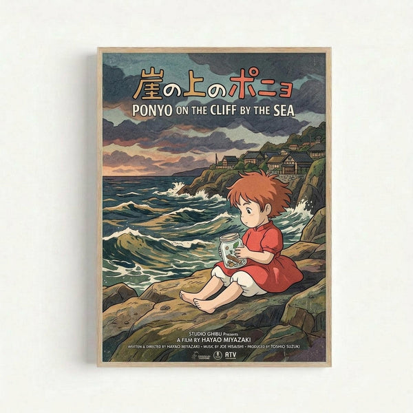 Framed poster featuring Ponyo character from Studio Ghibli sitting on rocky coastline holding a jar, with ocean waves crashing nearby and hillside village in background. Artwork shows orange-haired child in red dress against dramatic cloudy sky in traditional Japanese animation style. Light wood frame against white wall.