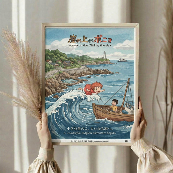 May include: Person holding framed poster print featuring Studio Ghibli's Ponyo anime artwork. Shows red-haired girl character emerging from ocean wave next to boy in wooden boat, with coastal village, lighthouse and mountains in background. Bright blue seas, green landscape, vintage Japanese animation style. Light wood frame, held against white curtained window with dried pampas grass decoration visible.