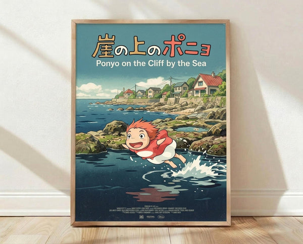 May include: Framed poster print in natural wood frame leaning against white wall on light wooden floor. Features Studio Ghibli anime art style showing red-haired character Ponyo swimming in dark blue ocean water with splash effects. Background shows coastal village houses on rocky cliffs under cloudy sky. Japanese and English text at top. Vibrant colors with teal, blue, coral and green tones in detailed illustration style.