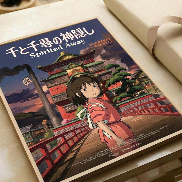 May include: Studio Ghibli Spirited Away poster print featuring Chihiro in red and white striped outfit standing on wooden deck before ornate multi-story bathhouse with traditional Japanese architecture. Rich colors include deep blues, warm reds, and golden lighting. Japanese and English text at top. Print shown on white surface with rolled papers nearby, displaying vibrant anime art style with detailed architectural elements and evening sky backdrop.