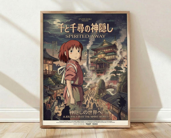 May include: Framed Studio Ghibli Spirited Away movie poster featuring anime girl with short reddish-brown hair in burgundy outfit standing before elaborate Japanese bathhouse with traditional architecture, bridges, and crowds of people. Poster displays both Japanese and English text against dramatic cloudy sky. Natural wood frame sits on light wooden floor against white wall with soft shadows.