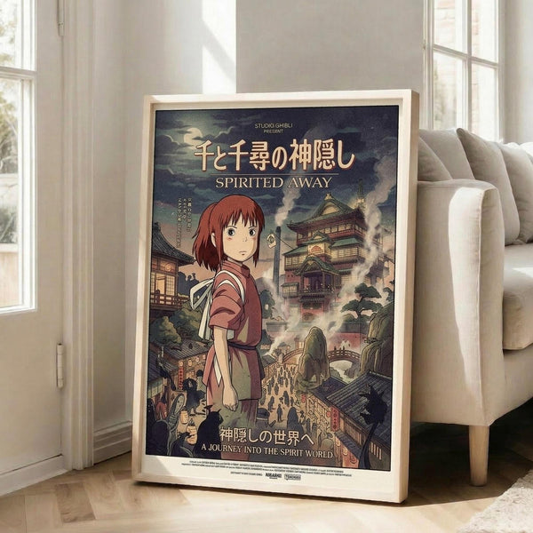 May include: A framed Studio Ghibli Spirited Away movie poster displayed in a bright living room corner beside a beige sectional sofa. The vintage-style poster features the red-haired protagonist Chihiro in traditional clothing against a fantastical Japanese bathhouse backdrop with ornate multi-story buildings, bridges, and mystical creatures. Japanese and English text overlay the dramatic cloudy scene in rich greens, browns, and golden tones within a natural wood frame.