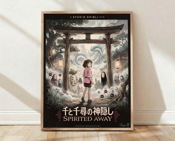 May include: Framed Studio Ghibli Spirited Away movie poster displayed on light wood floor against white wall with soft shadows. The colorful anime artwork shows a young girl in pink shirt standing before a traditional Japanese torii gate, surrounded by iconic film characters including No-Face, dragon, forest spirits, and magical creatures in a dreamy, ethereal scene with paper lanterns and mystical atmosphere.
