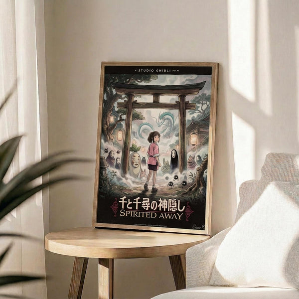 May include: Framed Studio Ghibli Spirited Away movie poster in natural wood frame displayed on round wooden side table next to beige upholstered chair. Poster features young girl character Chihiro surrounded by colorful spirits and creatures beneath traditional Japanese torii gate, with white dragon in cloudy sky above. Soft natural lighting creates gentle shadows across minimalist room setting with plant leaves visible in corner.