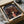 May include: Framed Spirited Away movie poster featuring young Chihiro in red striped outfit against twilight bathhouse backdrop, packed in cardboard shipping box with protective padding and wooden frame corners visible