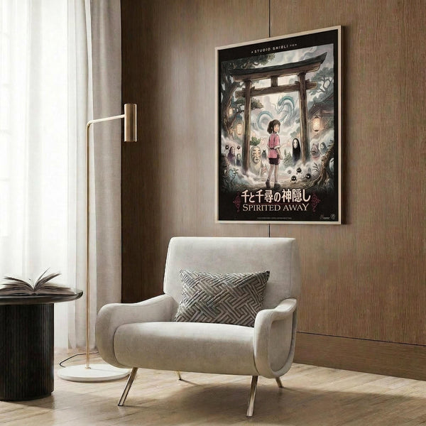 May include: Framed Spirited Away movie poster hanging on wood-paneled wall above beige upholstered armchair with geometric patterned pillow. Poster shows anime characters including young girl and mysterious black figure beneath traditional Japanese torii gate, surrounded by fantastical creatures in muted colors. Modern living room setting with brass floor lamp, dark round side table with open book, and white curtains.