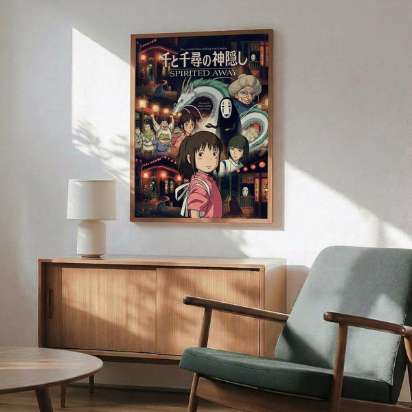 May include: Framed Spirited Away movie poster hanging on white wall above wooden credenza with lamp. Features colorful anime artwork showing young girl Chihiro in pink shirt surrounded by magical characters including No-Face, dragon, and bathhouse scenes. Modern living room setting with teal mid-century chair and round coffee table. Natural lighting creates geometric shadows on wall.