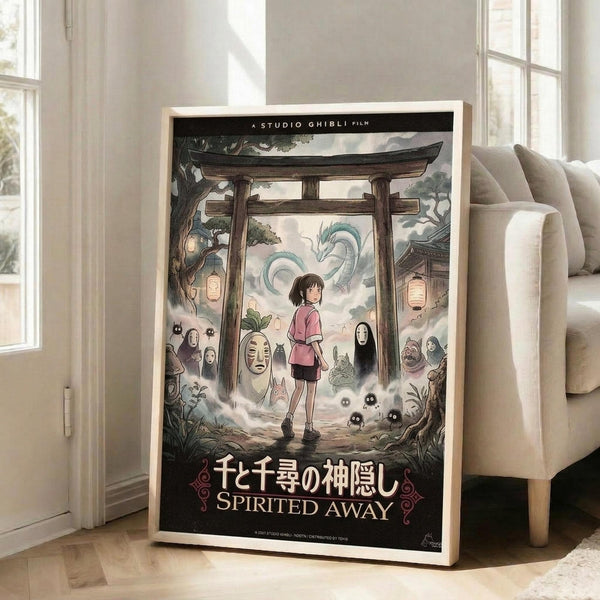 May include: Framed Studio Ghibli Spirited Away movie poster in light wood frame, leaning against white wall next to beige upholstered chair. Poster features young girl in pink shirt surrounded by Japanese torii gate, dragon, No-Face character, and other mystical spirits in muted greens and earth tones. Sunlight streams through windows onto hardwood floor in bright, minimalist living room setting.