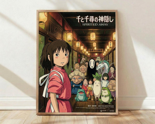 May include: Framed poster of animated film artwork featuring young girl in red kimono in foreground with various colorful spirit characters behind her in lantern-lit traditional Japanese street scene. Wooden frame sits on light wood floor against white wall with natural lighting creating soft shadows.