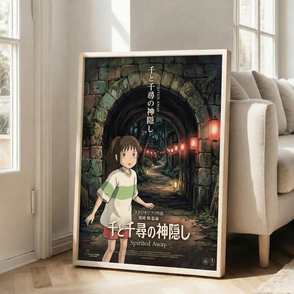 May include: Framed poster of animated film featuring young girl with brown hair in green and white striped shirt standing in stone archway tunnel with glowing red lanterns. Poster shows Japanese text and "Spirited Away" title. Wood-framed print leaning against white wall next to beige upholstered chair in bright room with large windows and hardwood floors.