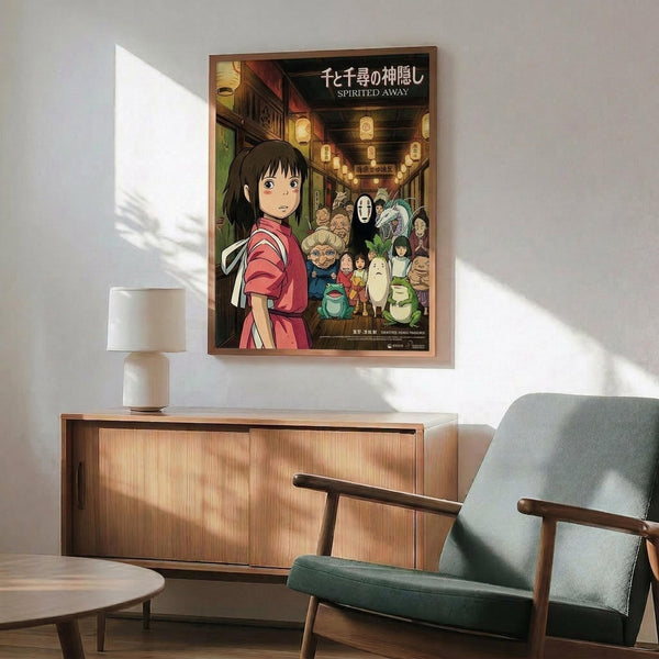 May include: Framed Spirited Away movie poster hanging on white wall above wooden sideboard with table lamp. Poster shows young girl in red outfit with various animated characters in traditional Japanese street scene with lanterns. Mid-century modern furniture including teal upholstered chair with wooden arms and round coffee table visible in foreground. Natural sunlight creates geometric shadows across the minimalist room setting.