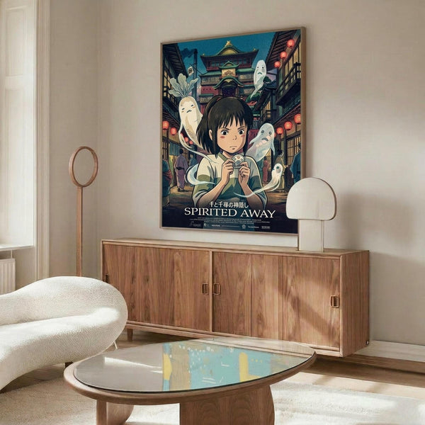 May include: Framed Spirited Away movie poster hanging above wooden credenza in modern living room. Shows young girl with dark hair surrounded by white spirits and traditional Japanese architecture. Poster features vibrant blues and warm lighting. Room has cream walls, white upholstered chair, glass coffee table, and minimalist decor with natural wood finishes.