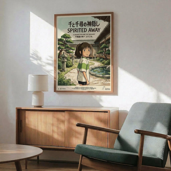 May include: Framed Studio Ghibli Spirited Away movie poster featuring anime character Chihiro in green and white shirt standing in traditional Japanese garden setting with stone lanterns and pathways. Poster displayed above mid-century modern wooden credenza with table lamp, next to sage green upholstered armchair with wooden frame in bright, naturally-lit room with white walls.