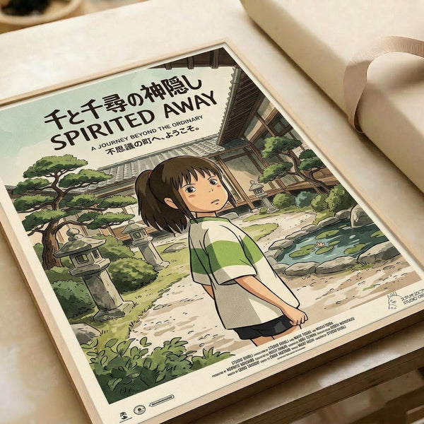 May include: Framed movie poster featuring animated character Chihiro from Spirited Away in green and white striped shirt, standing on stone path surrounded by lush greenery, traditional Japanese buildings, and pond with lily pads. Poster displays Japanese text at top with English subtitle "A Journey Beyond the Ordinary." Cream-colored frame rests against white cylindrical objects on neutral surface.