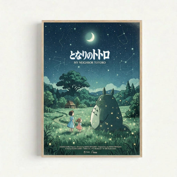 Framed poster featuring Totoro and two children in a moonlit meadow scene. The artwork shows a large gray forest spirit sitting beside two young girls against a starry night sky with crescent moon and constellation patterns. Rolling green hills, trees, and a small house create the pastoral landscape background. The image has a dreamy, animated film aesthetic with soft blues and greens. Japanese text appears at the top with English translation below. Studio credits are visible at the bottom of th
