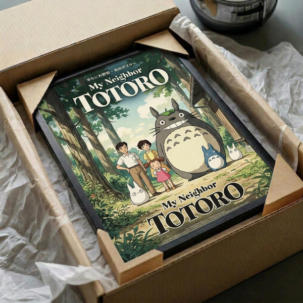 May include: Framed My Neighbor Totoro poster showing the iconic gray forest spirit with children in a lush green woodland scene, packaged in a cardboard box with protective wrapping paper. The vintage-style artwork features soft earth tones and detailed forest imagery, displayed as an unboxing scene on a neutral surface.
