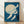 May include: Framed vintage Japanese woodblock print showing white cranes flying against deep blue sky with large pale moon. Art features delicate feather details and subtle brushwork textures. Natural wood frame sits on light wooden floor against white textured wall with soft shadows.