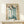 May include: Framed vintage Chinese artwork featuring five stylized cranes with long blue-green necks, brown heads, and black beaks against cream background with black calligraphy text. Light wood frame displayed on pale wooden console table with small white wrapped gift box. Minimalist setting with white wall backdrop.