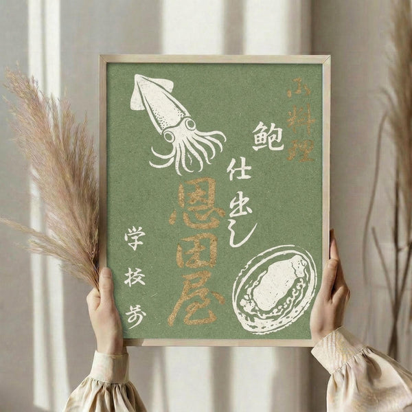 May include: Person holding framed vintage Japanese seafood poster with green background, featuring white illustrations of squid and abalone shell alongside Japanese text in white and golden brown colors. Dried wheat or pampas grass visible on left side. Neutral beige clothing and curtained background create soft, natural styling.