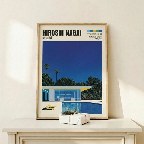 May include: Framed vintage-style poster featuring a modernist poolside scene with glass house, bright blue swimming pool, and palm trees against deep blue sky, displayed on light wood shelf beside small wrapped gift with dried grass decoration