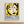 May include: Framed vintage exhibition poster with yellow background featuring stylized black and cream faces in Matisse's cut-out style, blue French text below, displayed on white wall above light wood surface in minimalist room setting.