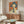 May include: Vintage Japanese Coca-Cola advertisement poster with woman in blue bob haircut holding bottle against orange background, displayed above mid-century walnut credenza in modern living room with white curved chair, brass floor lamp, and glass coffee table