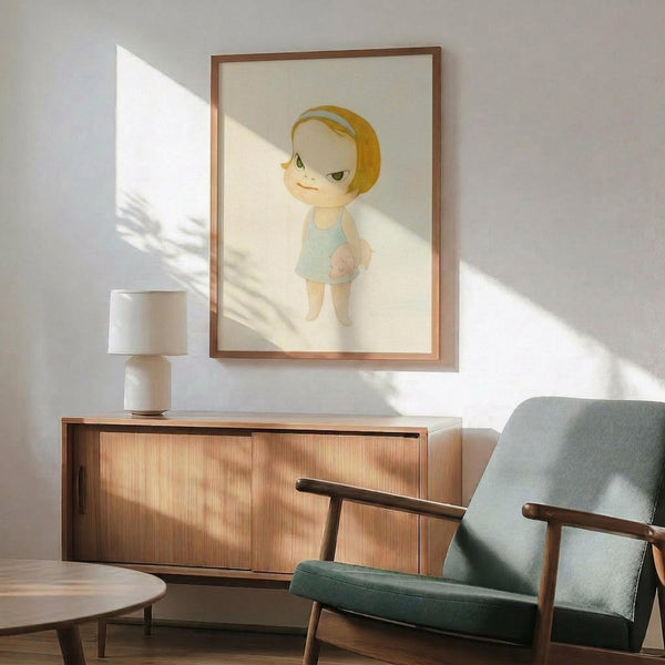 May include: Framed artwork showing a cartoon-style child with blonde bob haircut and green eyes wearing a light blue sleeveless outfit, displayed above a wooden sideboard with table lamp in a mid-century modern living room setting with teal upholstered chair and natural lighting creating shadows on white walls.