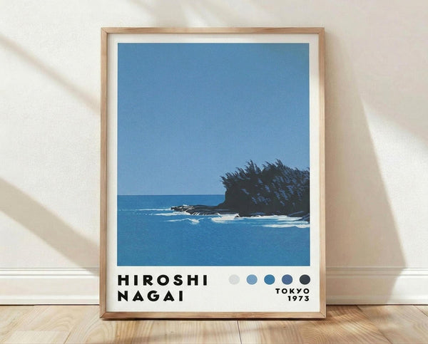 May include: Framed poster print featuring a minimalist coastal scene with blue ocean, small rocky island with dark vegetation, and clear blue sky. Modern design with bold black text below the image and five circular dots in varying shades of blue and gray. Natural wood frame with white matting, displayed on light wooden floor against white wall with soft natural lighting creating subtle shadows.