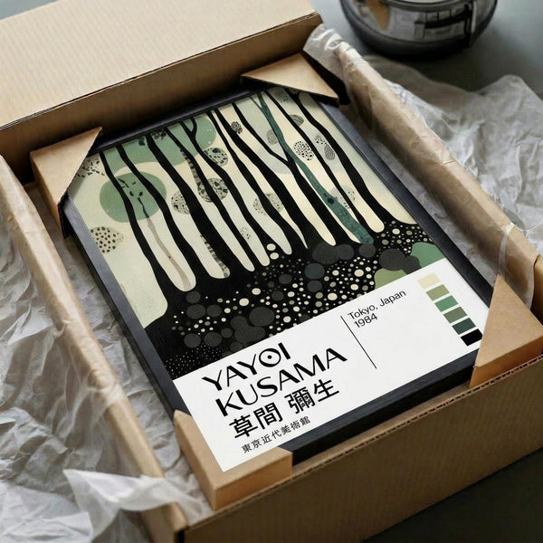 May include: Framed art print in cardboard shipping box with protective tissue paper and wooden ruler props. Abstract poster features vertical black drips over cream and sage green organic shapes with dotted patterns at bottom. White label shows artist name and Tokyo, Japan 1984. Minimalist contemporary art style with earth tone color palette.
