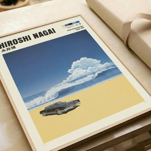 Retro-style poster print featuring a dark sedan car on sandy beige ground beneath a dramatic blue sky with large white cumulus clouds. The artwork has a nostalgic 1980s aesthetic with clean lines and vibrant colors. Black text "HIROSHI NAGAI" appears at the top with Japanese characters below. The print is displayed flat on a light wooden surface next to rolled white paper, showing the poster's clean white border and matte finish.