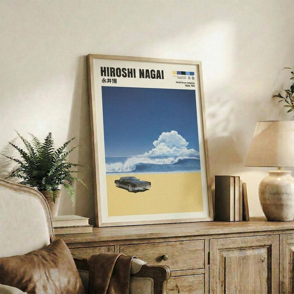 May include: Framed poster with blue sky, white clouds, ocean waves, and dark car on sandy beach, displayed on rustic wooden sideboard with beige chair, potted fern, ceramic vase, and stacked books in neutral-toned living room setting