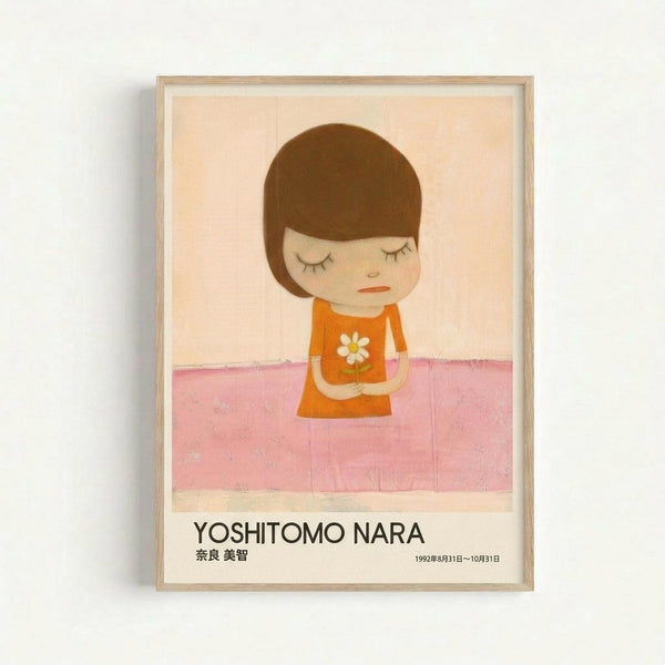 Framed poster featuring a minimalist illustration of a young child with brown bob haircut and closed eyes, wearing an orange dress with white daisy, standing against a pink and cream background. The artwork has a sweet, melancholic style with soft colors. Below the image is text reading "YOSHITOMO NARA" in black letters with Japanese characters and exhibition dates from 1992. The poster is displayed in a light wood frame against a white wall.