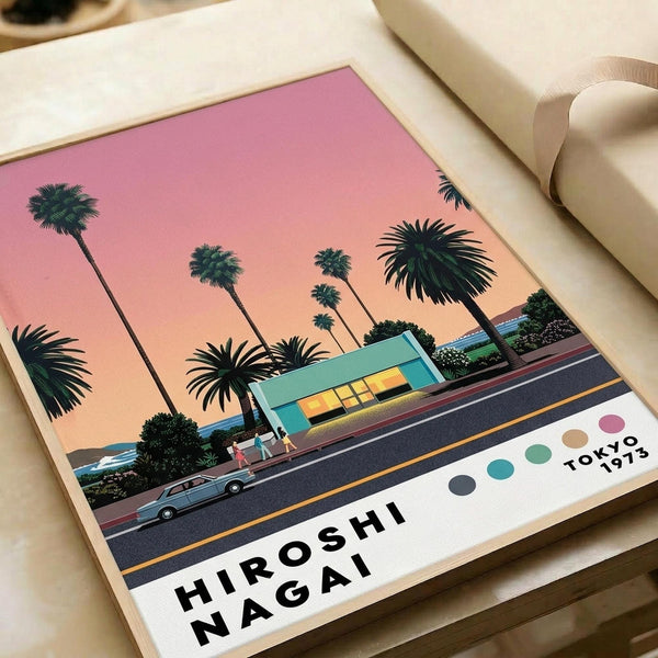 Retro-style illustration poster featuring tall palm trees silhouetted against a pink and orange sunset sky. A mid-century modern turquoise house sits beside a dark road with a vintage car. Bold text reads "HIROSHI NAGAI" at bottom with "TOKYO 1973" and colorful dots in corner. The artwork has a nostalgic 1970s aesthetic with vibrant tropical colors. Poster shown flat on white surface next to rolled paper tube.