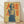 May include: Framed vintage-style poster featuring an Asian woman in white blouse and dark skirt holding a Coca-Cola bottle, with large red Japanese characters on yellow background. Wood frame sits on light wooden floor against white wall with natural shadow lighting.