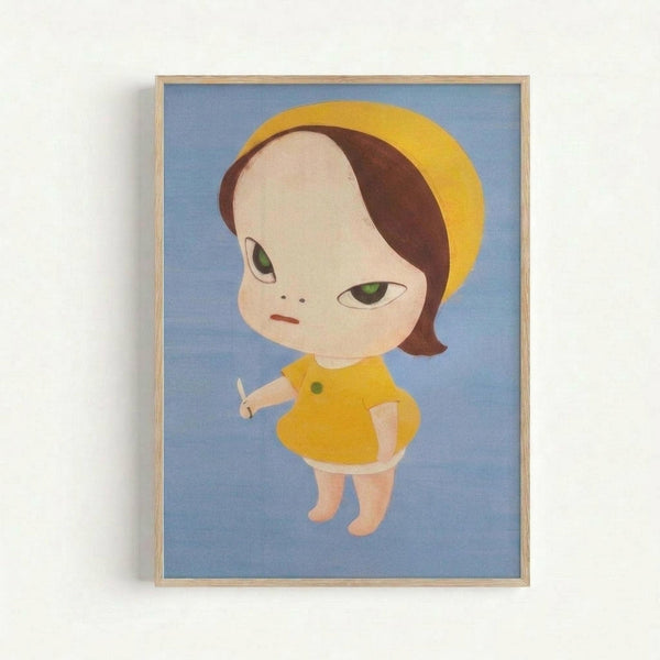 A framed artwork shows a stylized child-like character with an oversized round head, brown hair partially covered by a yellow hat or hood, and large green eyes with a somewhat melancholic expression. The figure wears a yellow dress or coat and holds a small white knife in one hand. The illustration has a simple, cartoon-like style with soft colors against a blue background. The piece is displayed in a light wood frame and hung on a white wall.